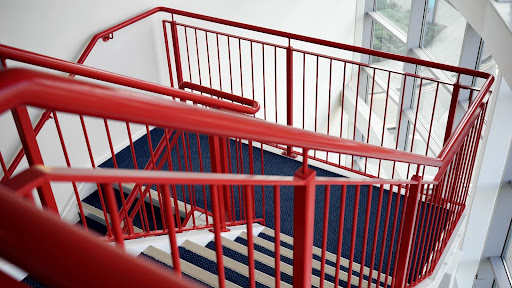 Red railings on blue stairs.